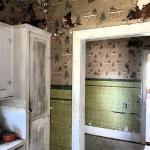 A view of the breakfast alcove from the kitchen. Visible is the original faux ceramic tile and wallpaper.